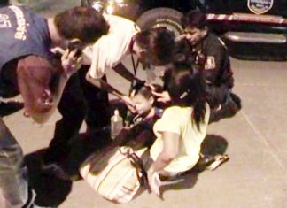 Jom Konprakun and her young son are helped by medical staff at the scene of the crash.